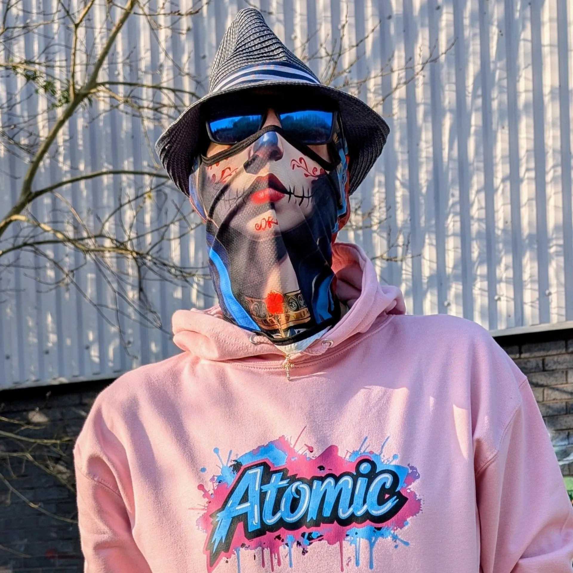 The Sun Walker wearing a Al Hazzati Atomic New Wave baby pink hoodie in Manchester graffiti location